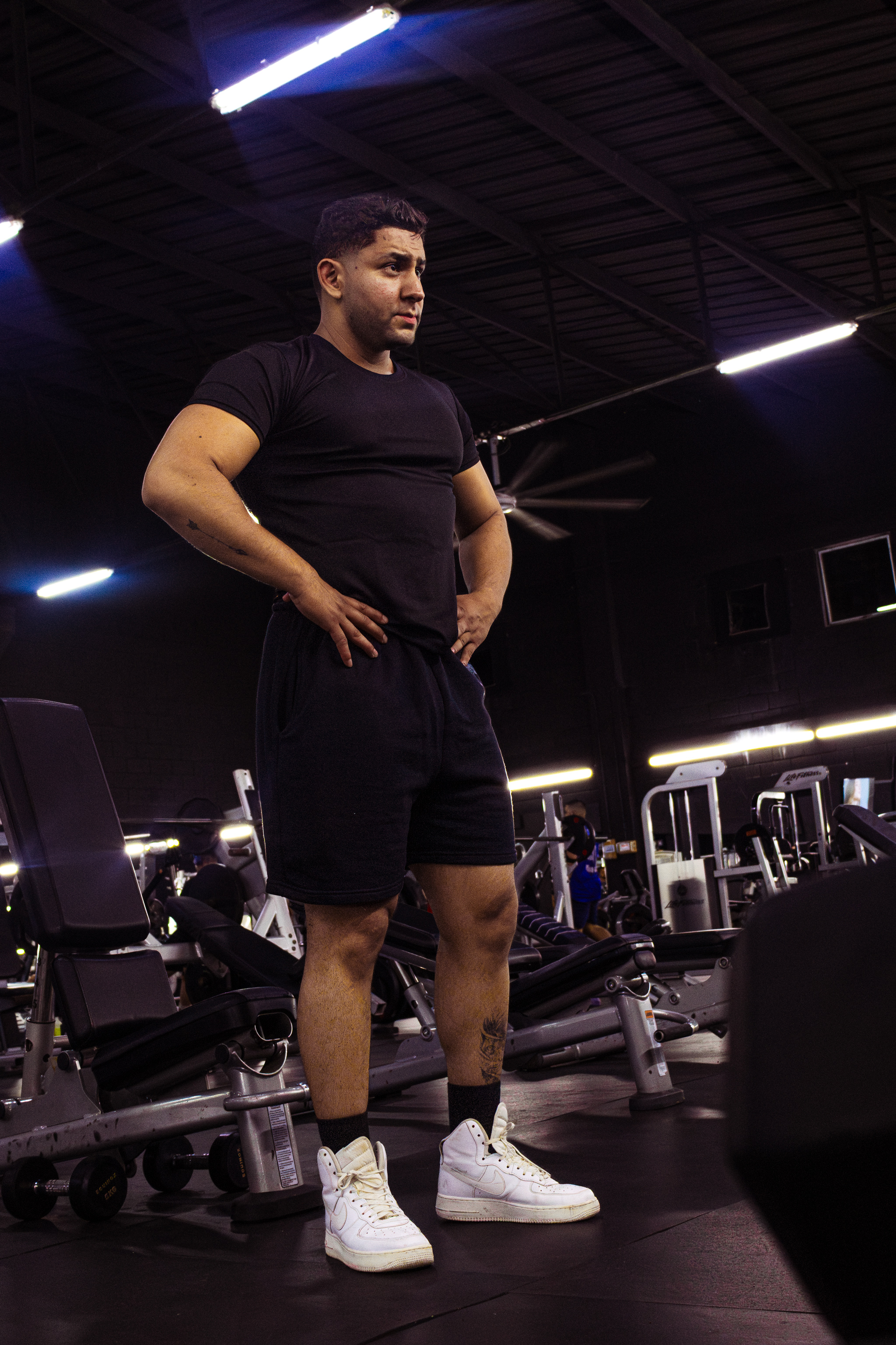Atleta Hustform de pie bajo la iluminación del gimnasio