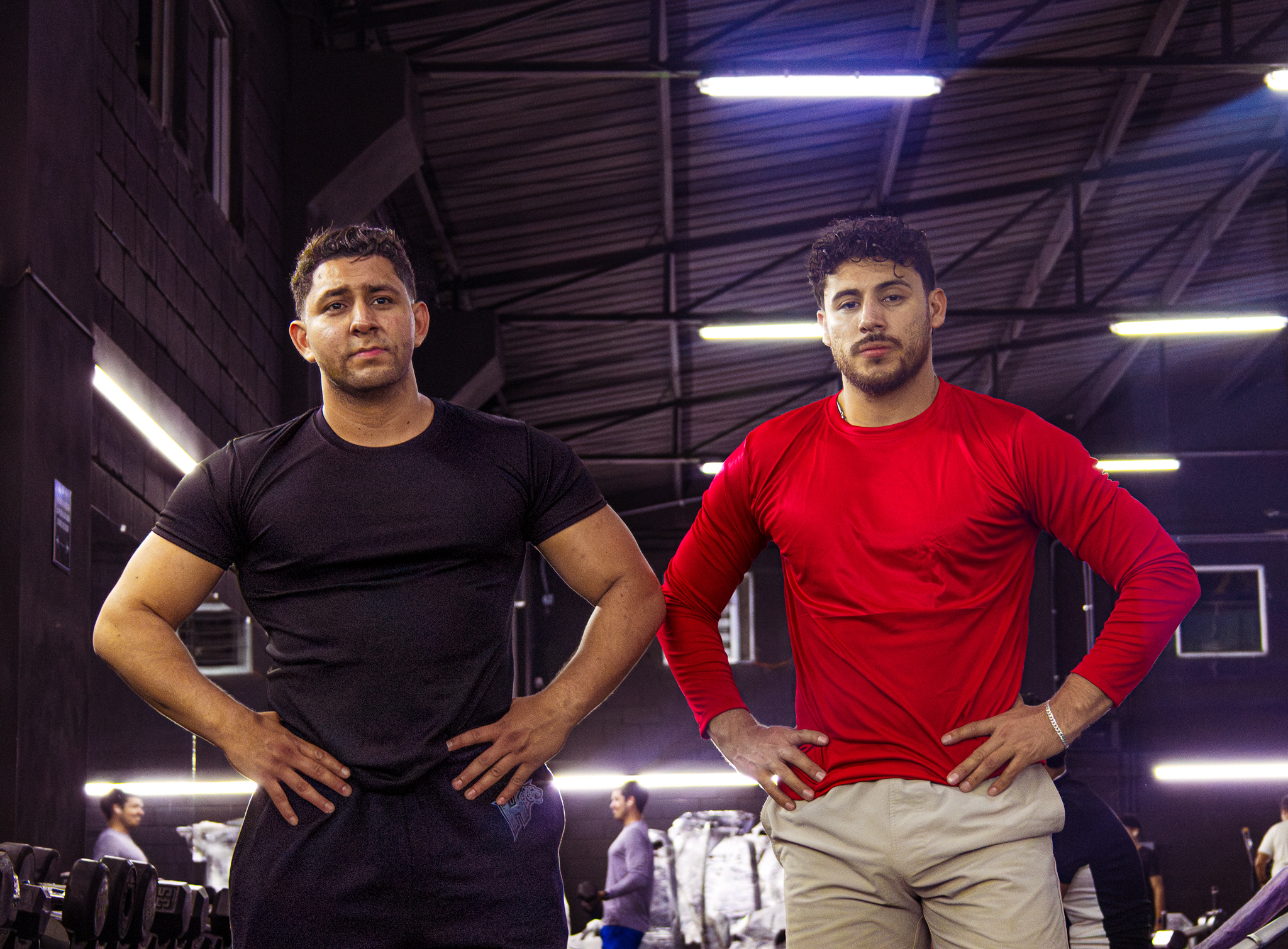 Dos atletas Hustform de pie uno al lado del otro en el gimnasio