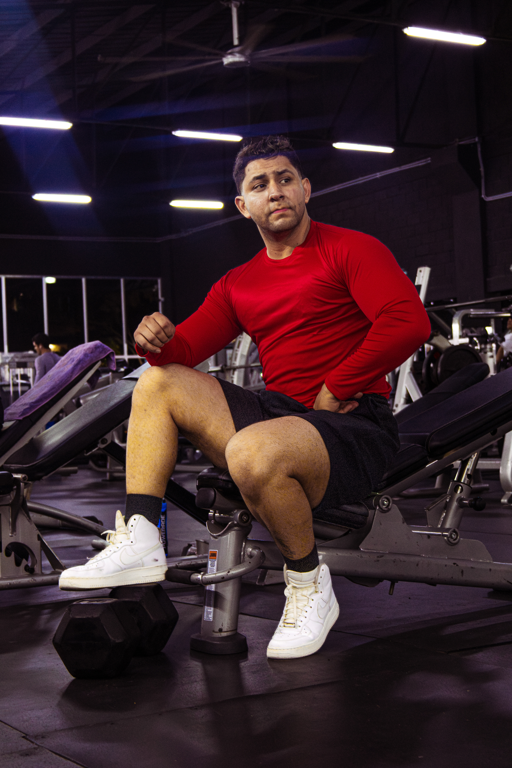 Atleta Hustform sentado en un banco con ropa de entrenamiento roja