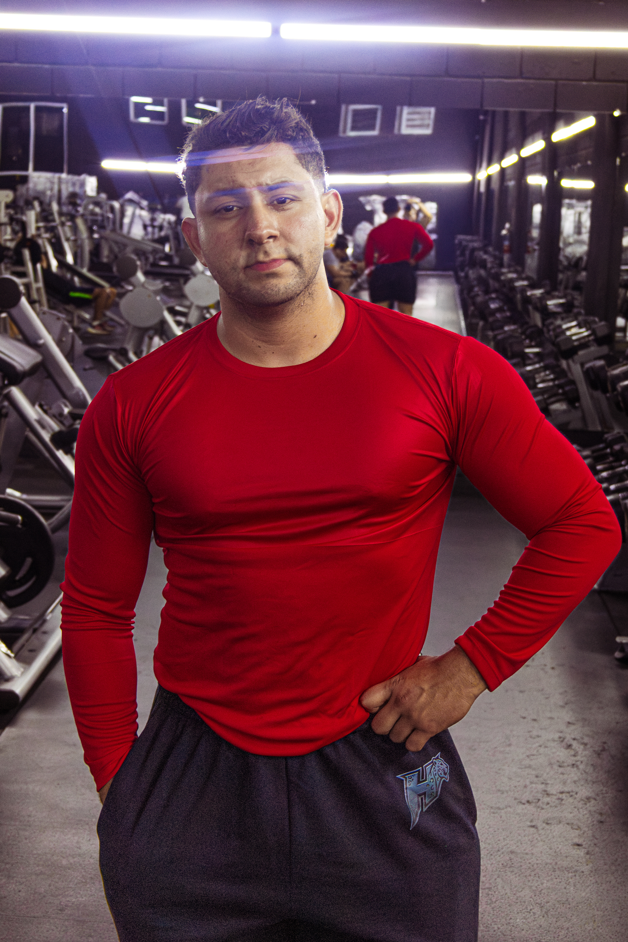 Atleta Hustform mirando a cámara con ropa de entrenamiento roja