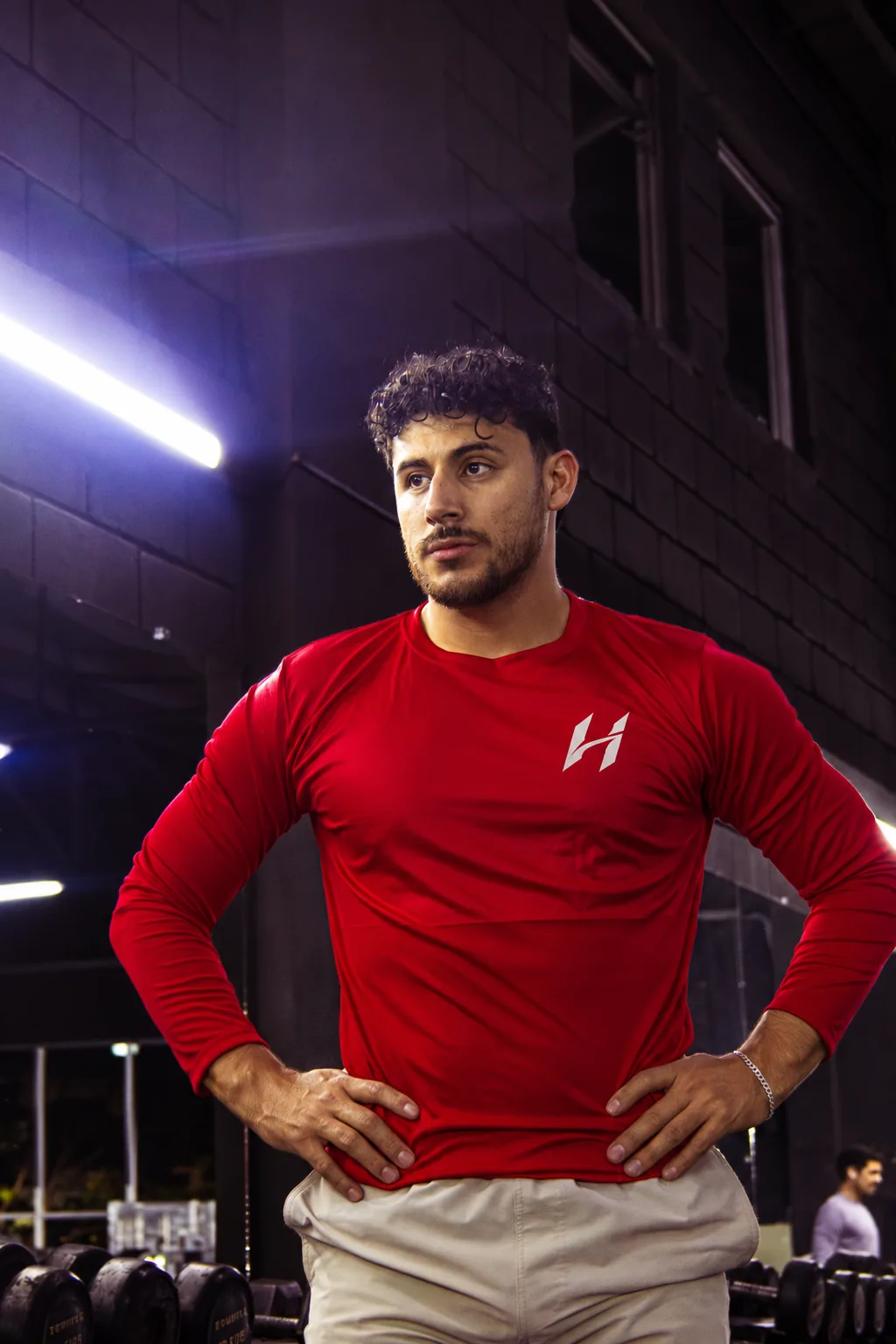 Atleta Hustform con camiseta roja de manga larga mirando de frente
