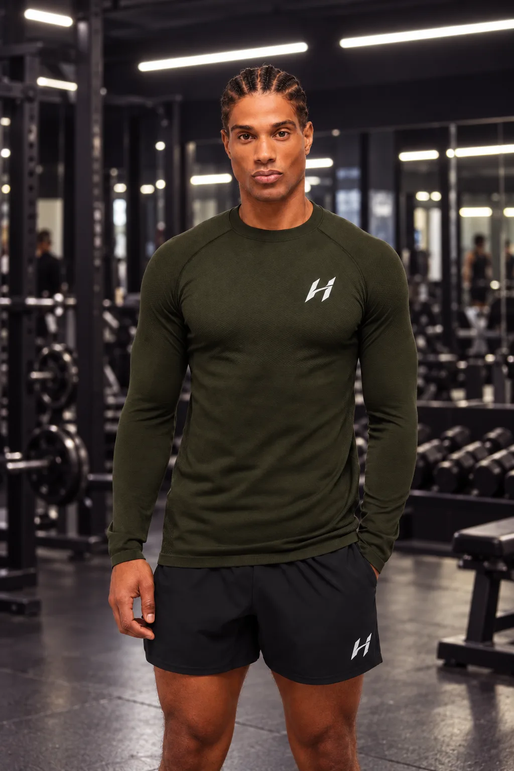 Atleta Hustform de pie con camiseta técnica verde militar de manga larga